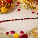 Close-up of traditional handmade red black thread rakhi with beads
