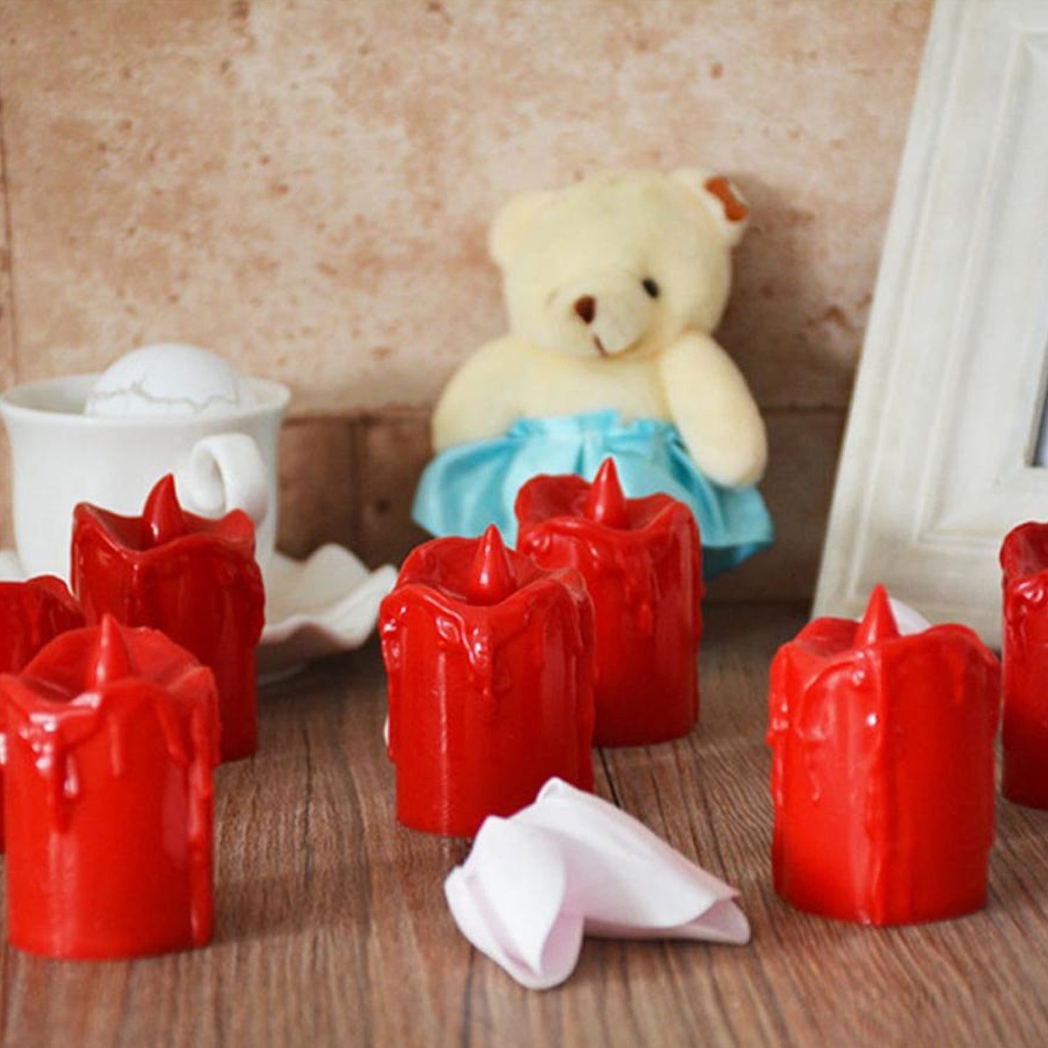 A set of 24 multicolor flameless LED candles with a melted wax design, glowing warmly.