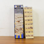 The Wooden Tumbling Tower Game set stacked high on lush green grass, perfect for outdoor fun.