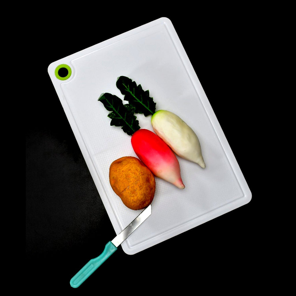 Robust plastic cutting board, perfectly sized for chopping veggies and fruits efficiently.