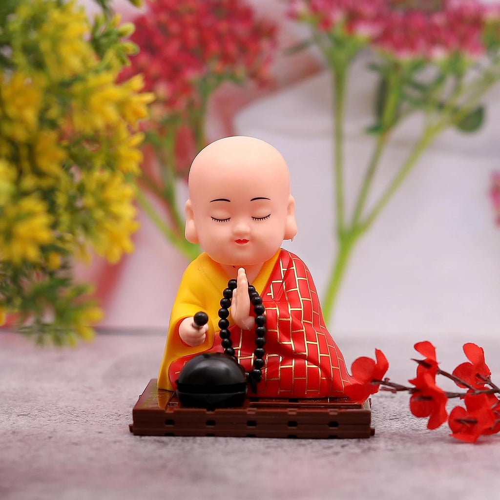 Front view of a solar Buddha statue with a gently moving head and hand, placed indoors.