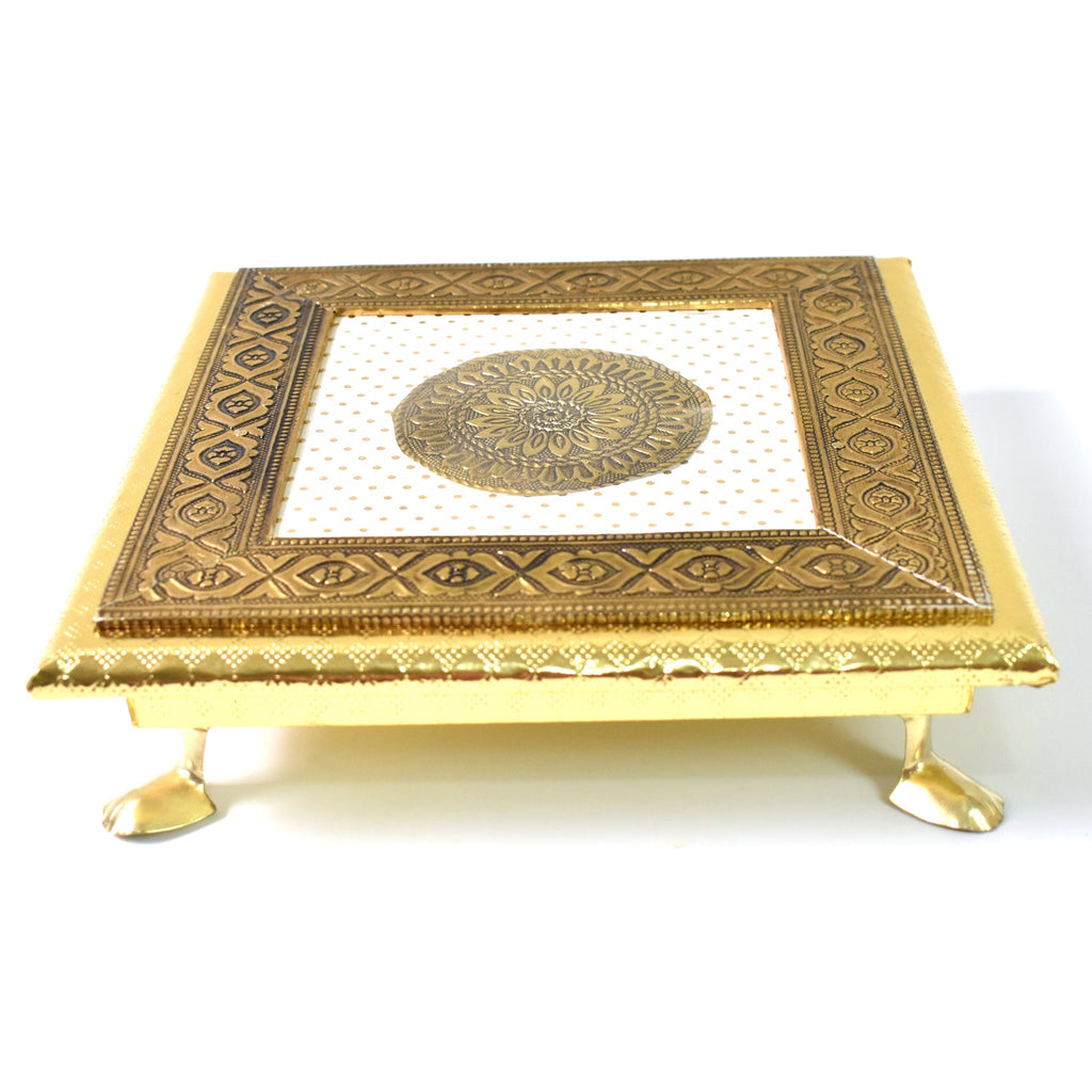 Detail shot of the golden Pooja Bajot featuring a delicate lotus motif.