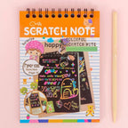 A child's hand scratching a rainbow art scratch book, revealing vibrant colours.