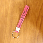 Silicone wrist strap keychain resting on a table with keys