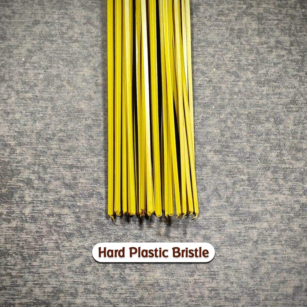 Detailed view of the hard bristles and plastic handle of the durable cleaning broom.