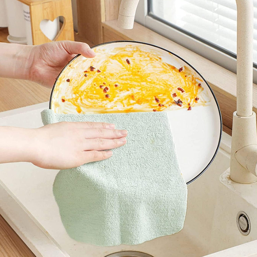 Microfiber cleaning cloth effectively wiping and shining a glass window.