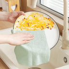 Microfiber cleaning cloth effectively wiping and shining a glass window.