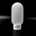 A single 60ml reusable plastic travel bottle in a vibrant mixed color, ready for toiletries.