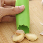 Silicone garlic peeler tube placed beside garlic cloves