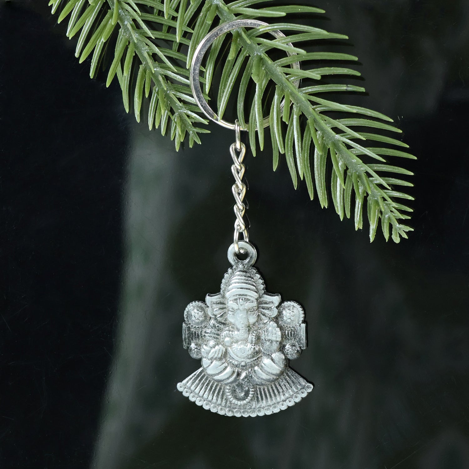 Close-up showing detailed Lord Ganesha sitting design on metal keychain