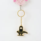 Golden Shivling keychain displayed on white surface showing metal craftsmanship
