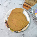 Maniarr's Ragi Khakhra chips arranged artistically with ingredients like ragi and wheat.