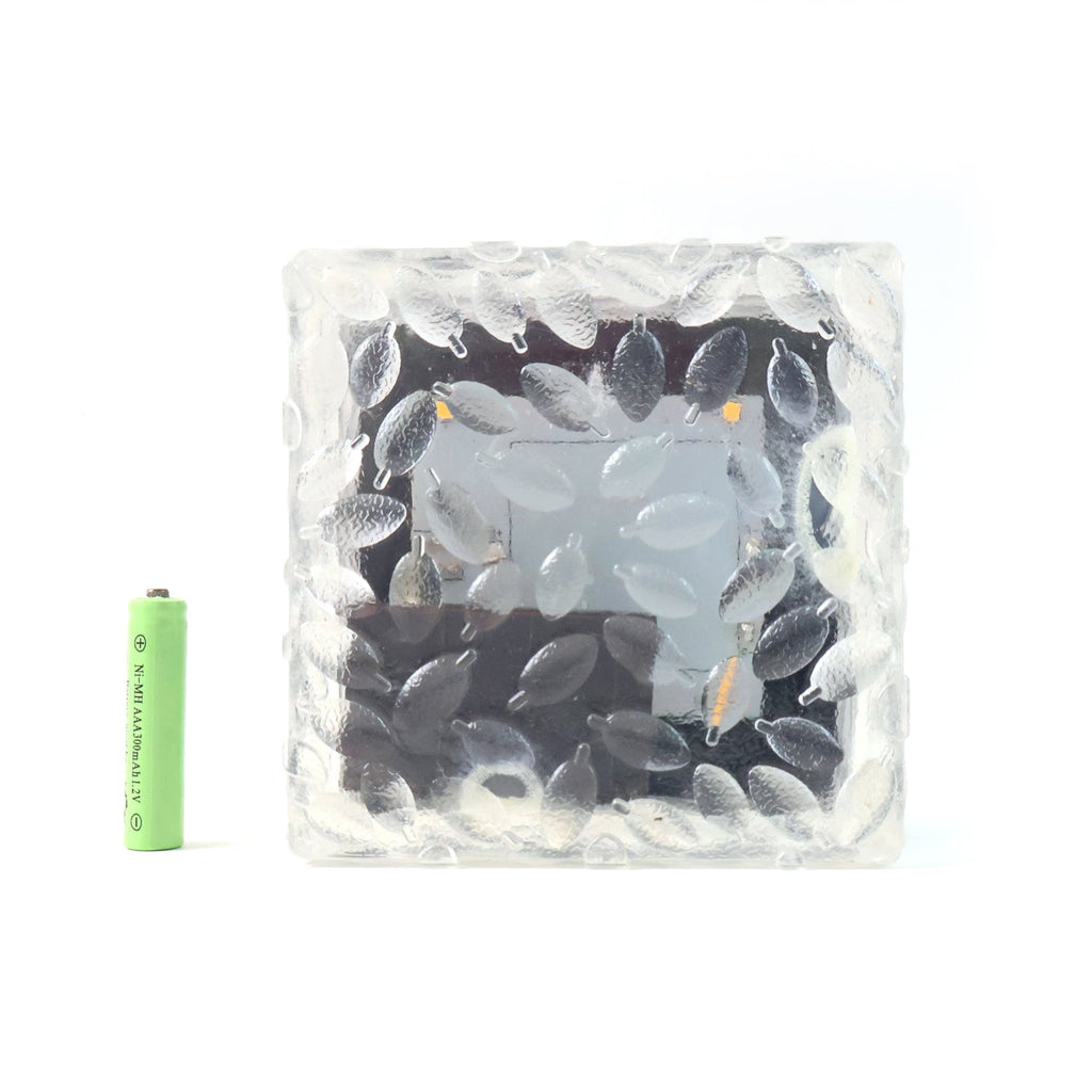 A solar powered ice cube light floating gently on water, ideal for pool decor.