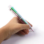 Transparent multicolor pen resting on a notebook ready for writing and note-taking.