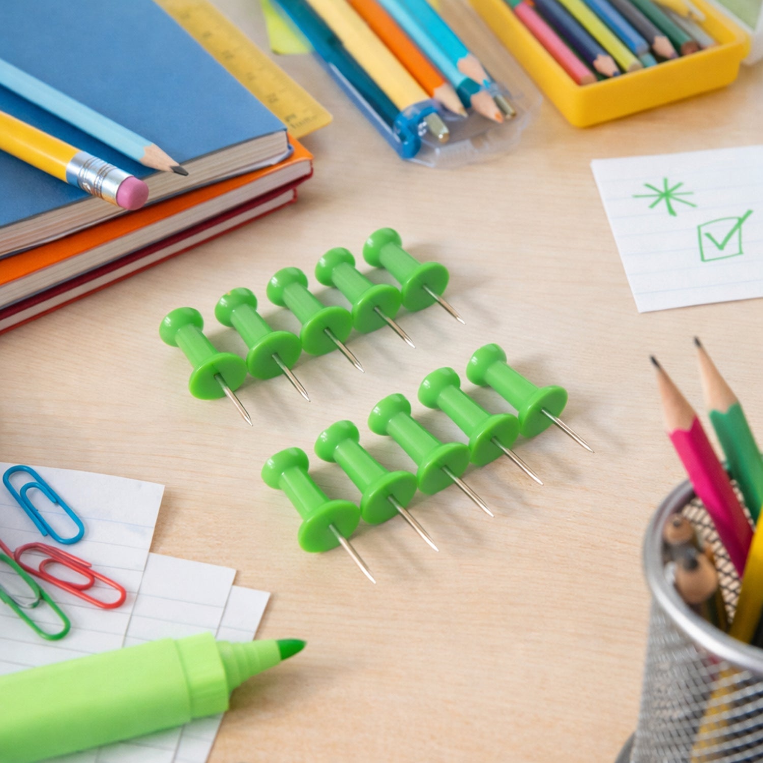 Close-up view of a green thumb tack with plastic easy grip head