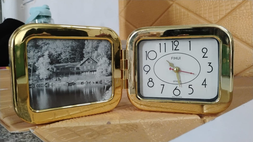 Foldable desk clock on a bedside table providing easy time access