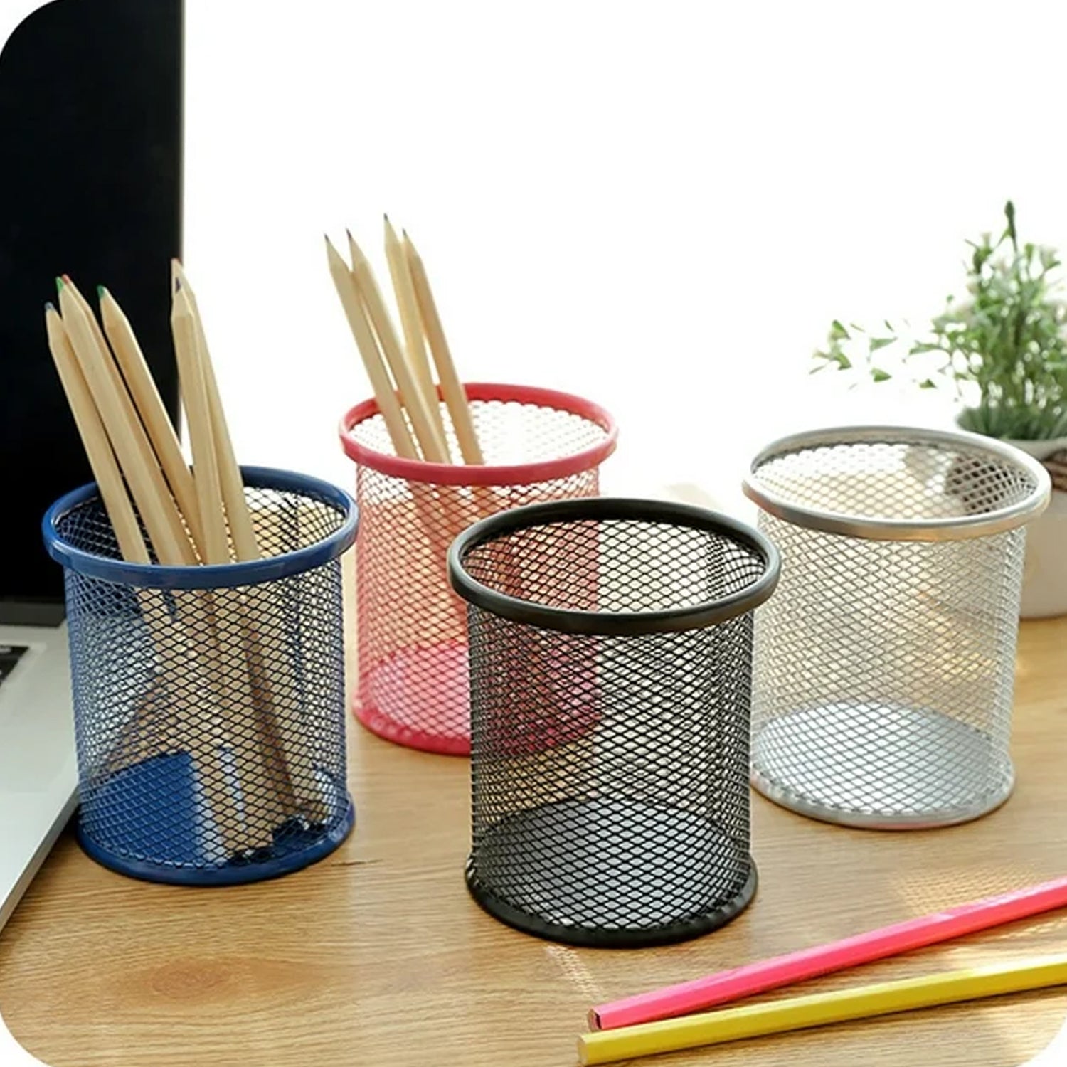 Black metal mesh pen holder, perfect for organizing an office desk.