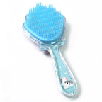 A child's hand holding a cartoon detangling hair brush, showing its comfortable grip and compact size.
