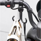 Multi-purpose stroller hook holding shopping bags and a purse on a pram.