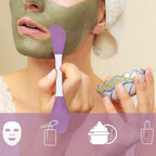 Hand demonstrating the gentle application of a face mask with the flat silicone brush end.