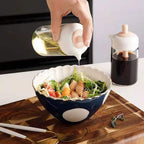Sleek glass oil bottle with built-in silicone basting brush for cooking.