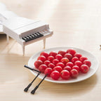 Cute piano-style fruit forks adding a whimsical touch to a fruit platter, perfect for fun snacking.