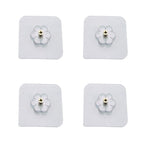 Transparent self adhesive hooks seamlessly blending into a tiled wall.
