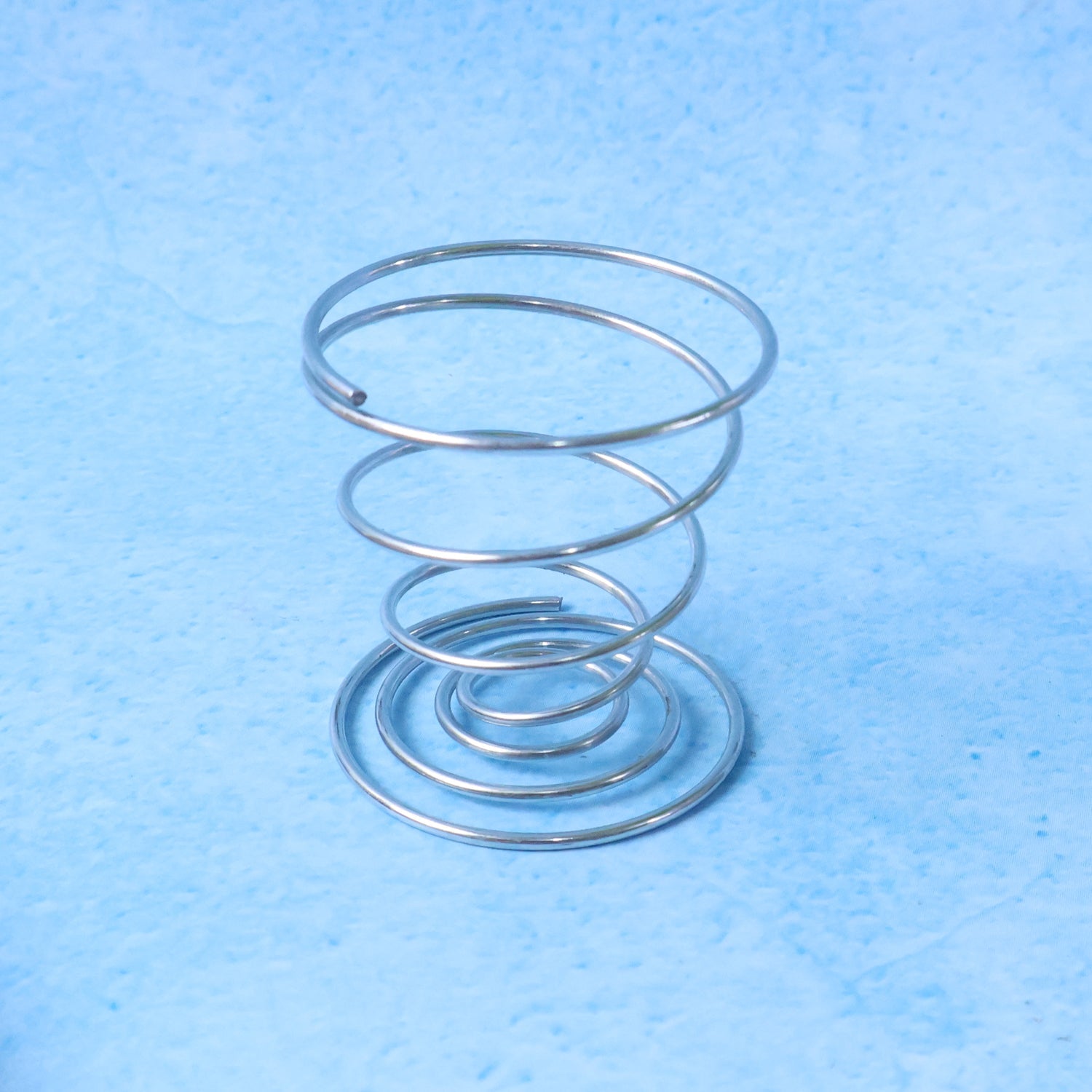 Modern stainless steel spiral egg cup holder enhancing dining presentation
