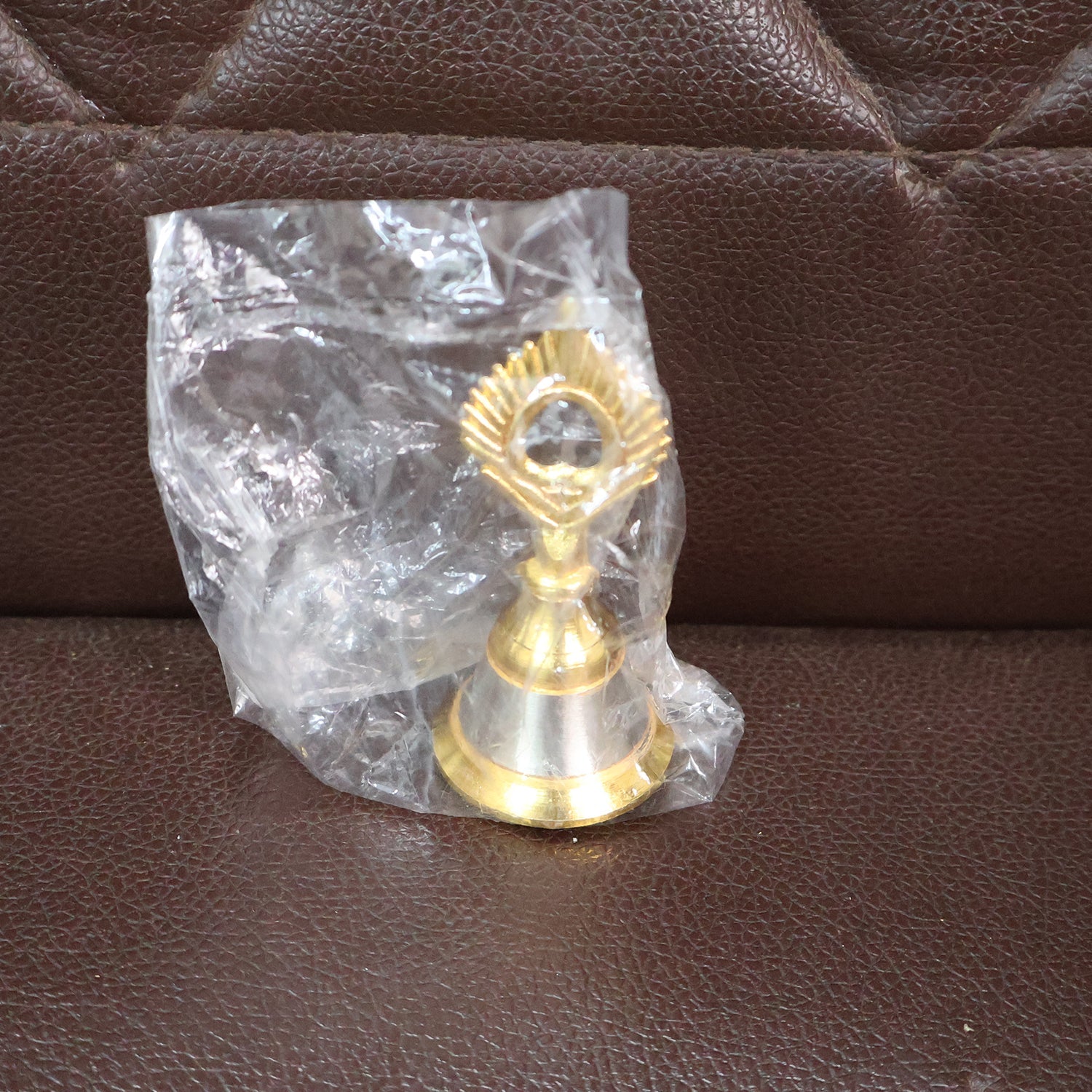 Decorative brass and steel pooja bell displayed on a home altar