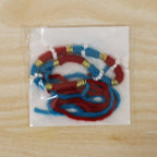 Festive handmade red thread rakhi with pearl detailing