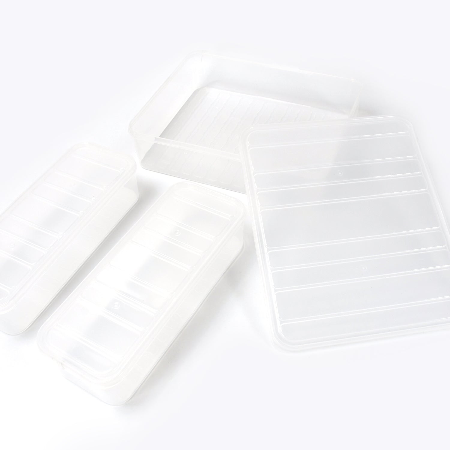 A person placing a transparent plastic food storage container filled with food into a refrigerator.