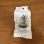 Metal temple bell keychain resting on textured surface background