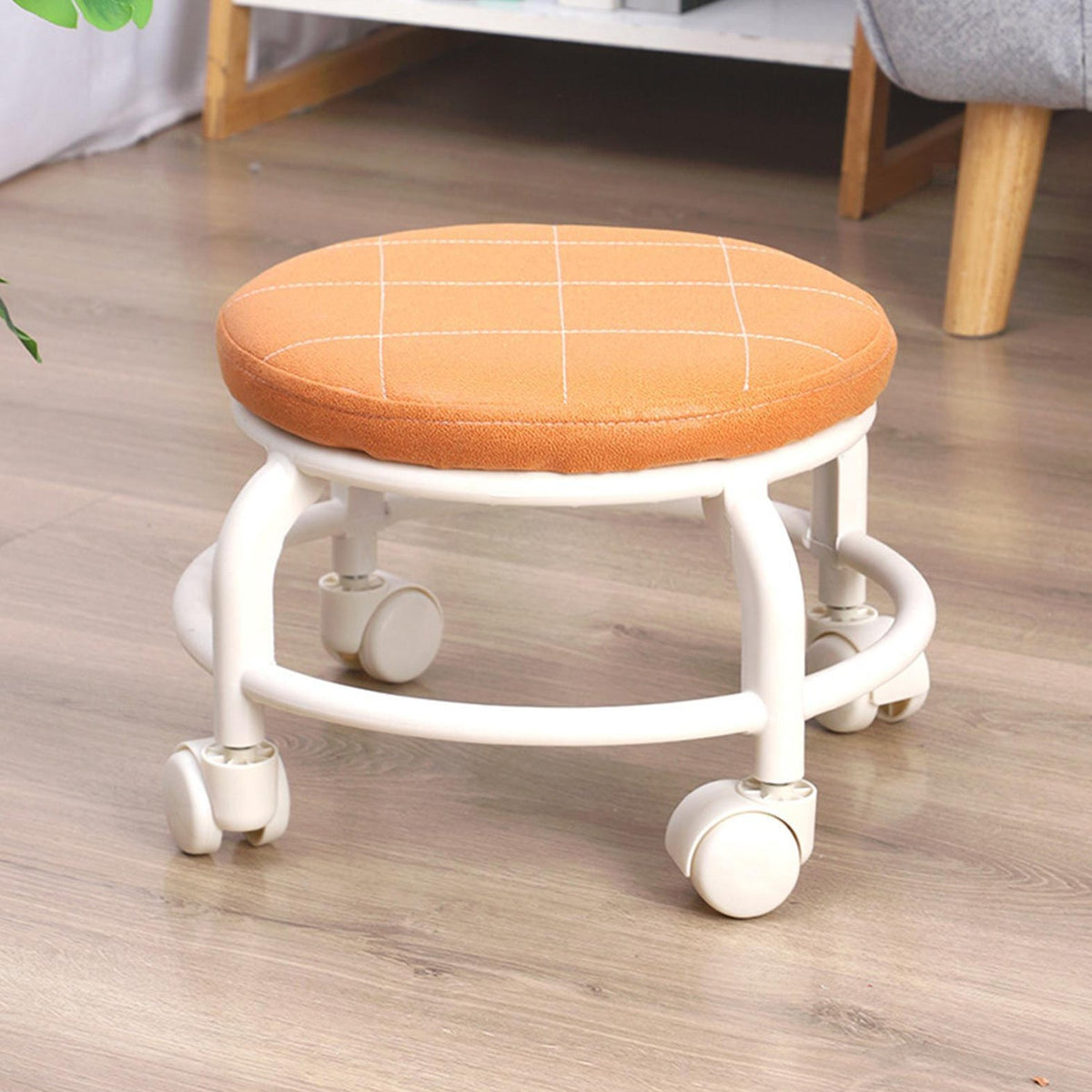 Low height rolling stool in white, designed for easy movement across floors.