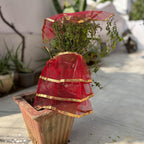 Gold-bordered red tulsi vastra pooja cloth draped elegantly for religious use