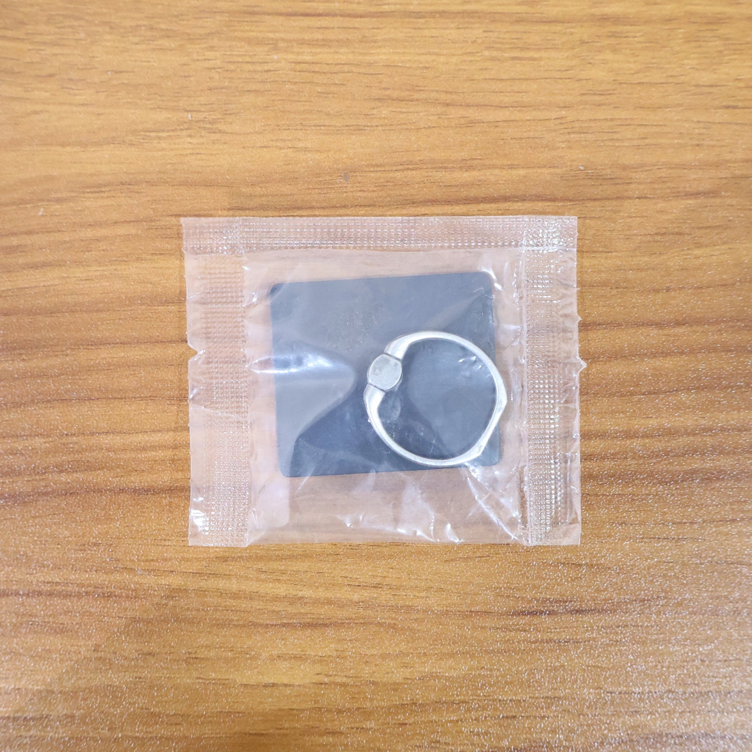A hand holding a smartphone securely using the attached phone ring stand.