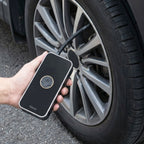 Air pump inflating car tyre on wheel with portable design