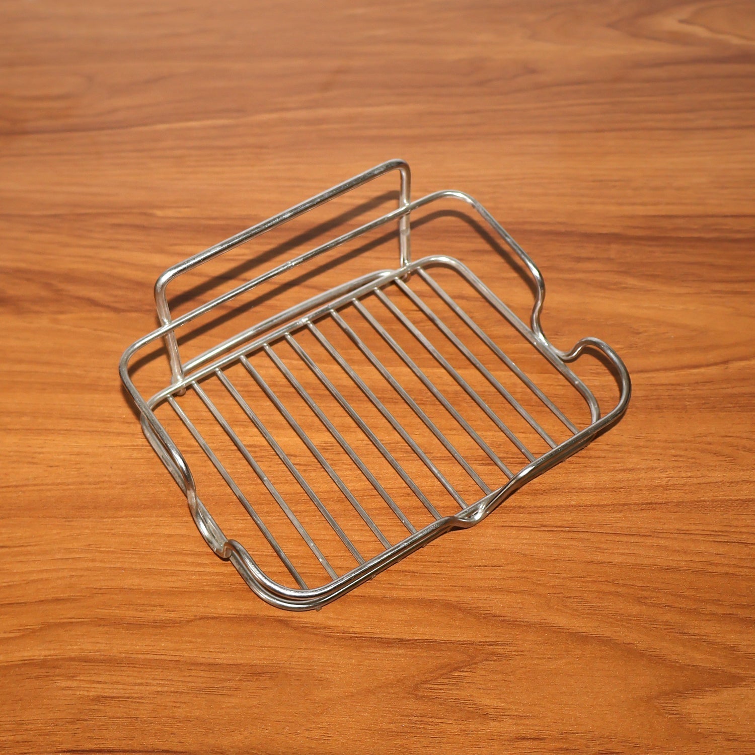 Stainless steel soap holder placed beside kitchen sink area for soap storage