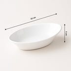 White Marin oval serving bowl placed next to other kitchenware items