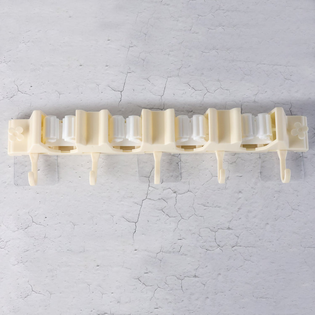 Close-up of self-adhesive broom holder rack mounted on home wall