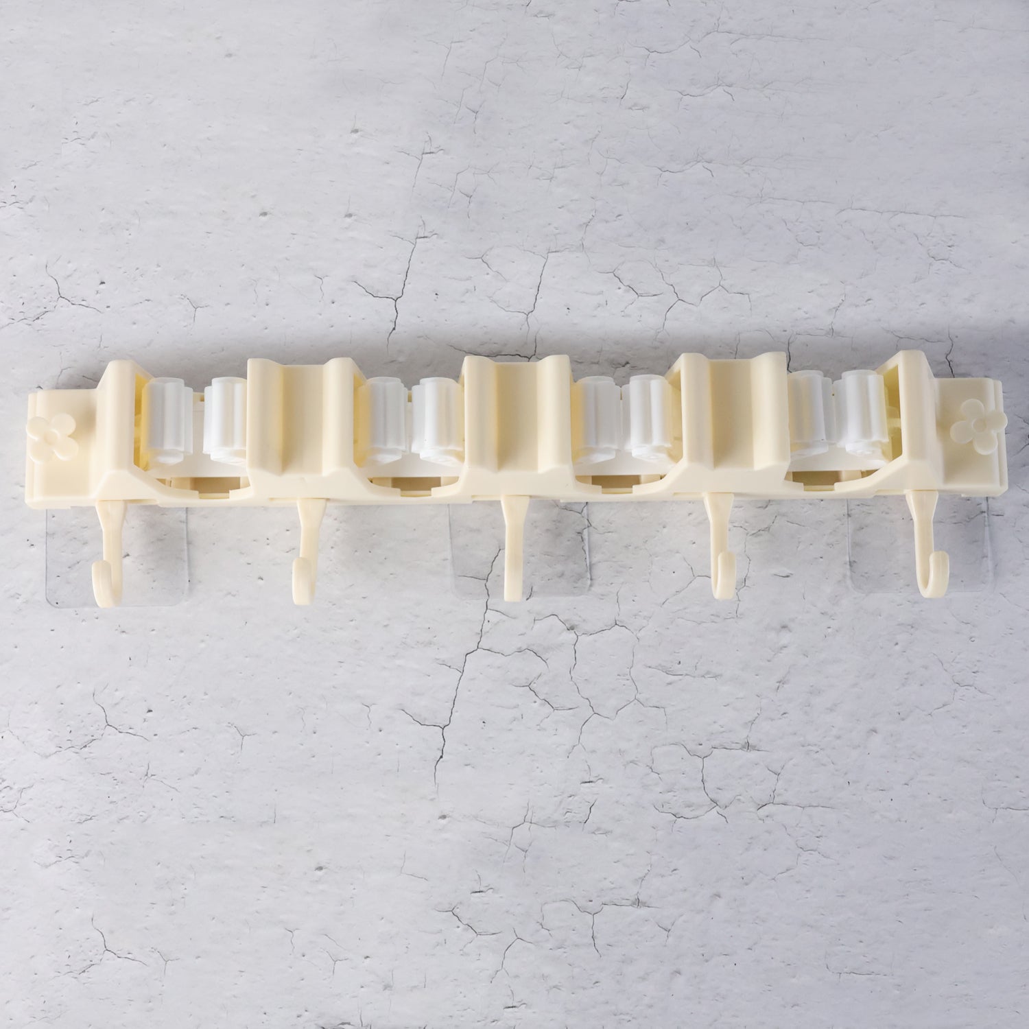 Close-up of self-adhesive broom holder rack mounted on home wall