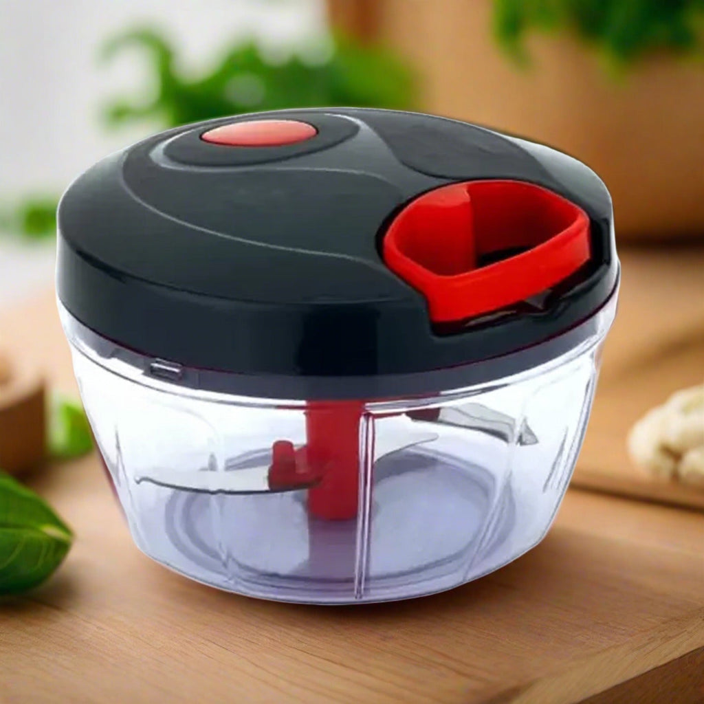Manual food chopper with transparent bowl and green lid, ready for use on a kitchen counter.