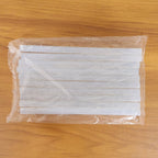 Hot glue sticking wood, fabric, and paper for craft projects