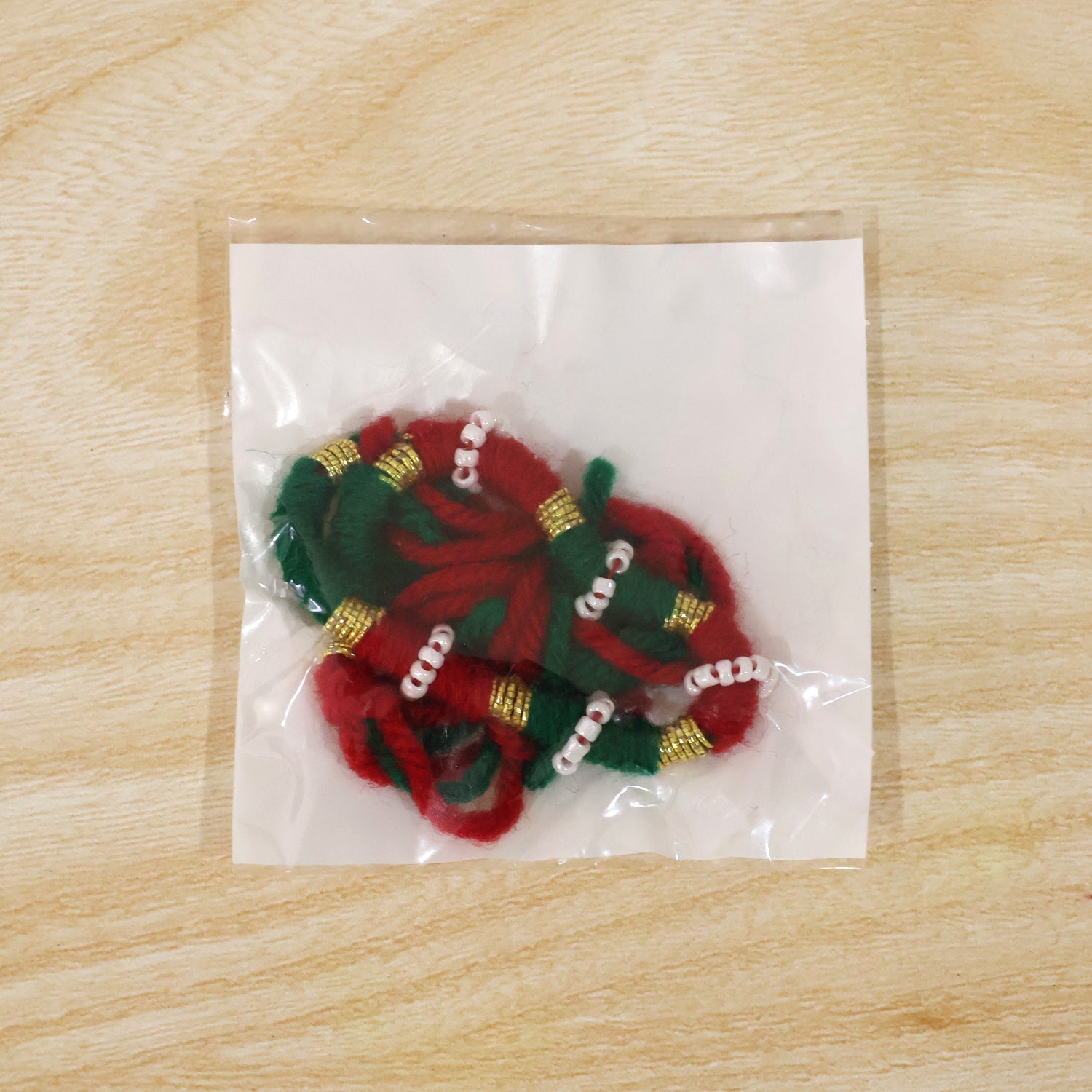 Closeup of golden beads on red green thread rakhi