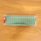 Close-up of high-quality fabric and grid pattern on the green pouch.