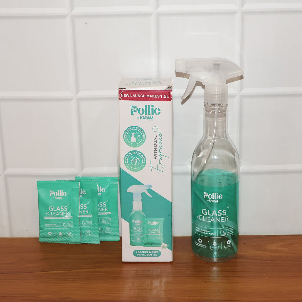 Spray bottle misting concentrated glass cleaner solution on glass surface for cleaning.