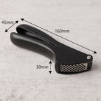 Angled view of a manual garlic press crusher tool showing construction