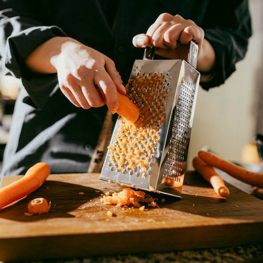 Multipurpose stainless steel grater with stable base for safe kitchen use.
