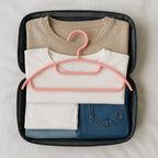 Close view of non-slip plastic hangers protecting delicate fabrics in closet