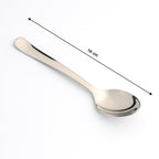 Stainless Steel Dining Spoon resting on a plate, ready for a meal, showcasing its balance.