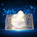 A clear plastic Iceberg Night Light illuminating a dark room, showcasing its unique design.